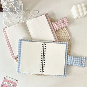 Detail of floral fabric notebook covers with button closures and spiral binding