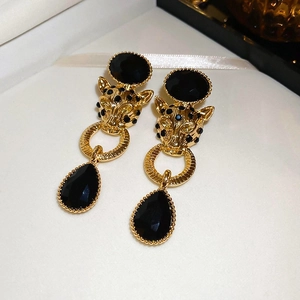 Detail of vintage panther earrings with black drop pendants and golden metallic finish
