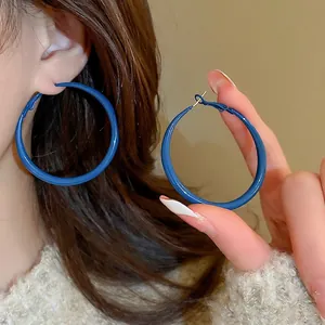 Minimalist large Klein blue hoop earrings with glossy finish for a retro stylish look