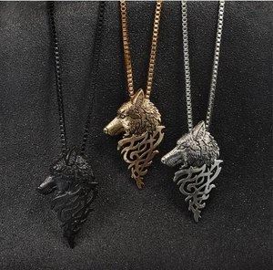 Gros plan de colliers tête de loup rétro en noir, or et argent avec des détails en relief