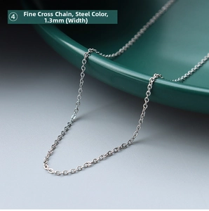 Macro shot of 1.3mm fine cross chain in steel color on a green ceramic plate