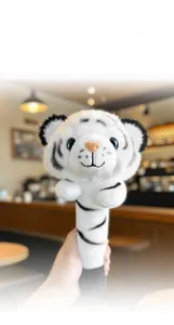 Detail of white tiger plush massage stick featuring soft faux fur and blue sequin eyes
