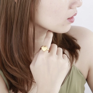 Bague cœur minimaliste en acier inoxydable doré portée au doigt d'une femme