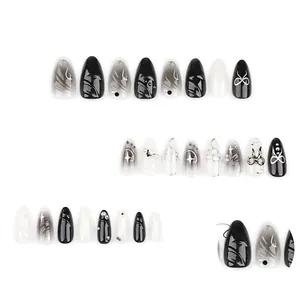 Faux ongles 3D avec effet marbré fumé noir, étoiles argentées et nœuds perles