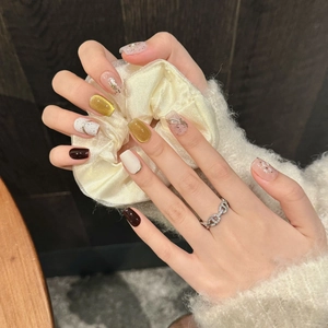 Elegant handcrafted press-on nails set in burgundy and gold cat-eye with silk scrunchie