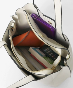 Macro detail of the interior compartments and zip closure of the cream PU tote bag