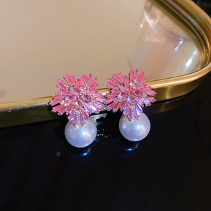 Pink zircon flower earrings with round white pearl drop in high-end jewelry display