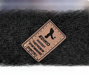 Close-up of the brown leather logo patch on a black fleece-lined warm winter baseball cap