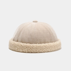 Detail of cream docker hat showing corduroy crown and plush faux fleece texture