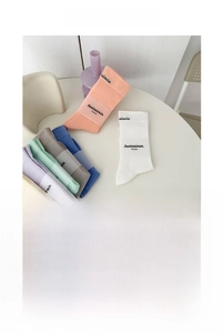 Detailed view of mid-calf cotton socks in cream colors with stylish letter prints