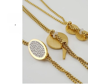 Dettaglio macro di collane in acciaio inossidabile placcato oro 18K con strass