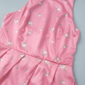 Detailed view of pink rose floral print on silky satin fabric with pleated waist design