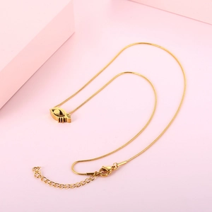 Golden eye-shaped pendant necklace in titanium steel on a soft pink background