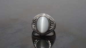Macro shot of retro stainless steel ring featuring an oval cat eye stone with relief detail