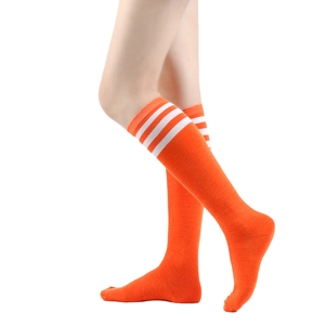 Close-up of vibrant orange knee high socks with three white stripes on model legs