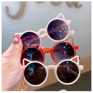 Detailed view of pink, orange and beige cat-ear sunglasses for kids with dark lenses