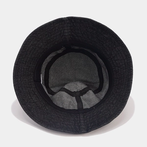 Detail showing internal structure of black denim bucket hat with sweatband and label