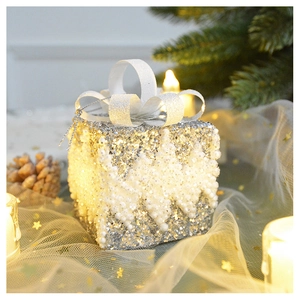 Close-up of glittery Christmas gift box ornament with silver sequins and white beads