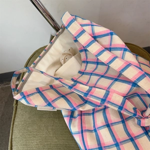 Detail view of the plaid cotton canvas tote bag showing inner lining and small pocket