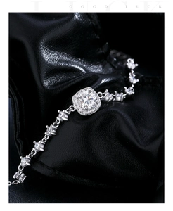 Macro shot of silver geometric square-cut moissanite bracelet on black leather texture