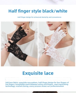 Close-up of black and white lace fingerless gloves with delicate rose flower pattern