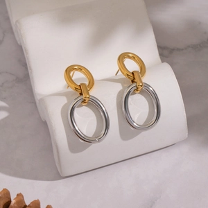 Gros plan de boucles d'oreilles ovales bicolores sur un présentoir ondulé