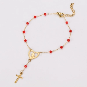 Detail of gold heart pendant with Virgin Mary icon and cross on beaded bracelet