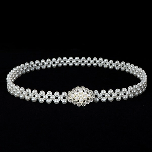 Detailed view of elastic pearl waist belt with a crystal flower buckle for women