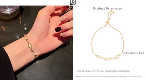 Detail view of gold chain bracelet with cat-eye fish stones and adjustable slide clasp