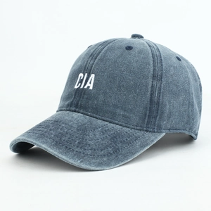 Detailed close-up of CIA letter embroidery on washed denim baseball cap with vent holes