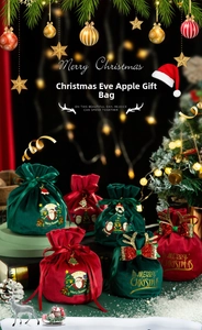 Close-up of velvet Christmas gift bags with gold Merry Christmas lettering and drawstring