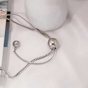 Macro shot of silver-tone layered snake chain with polished metal bead adjustment detail