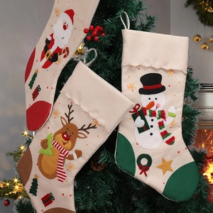 Three Christmas stockings with Santa, reindeer and snowman hanging on a decorated tree