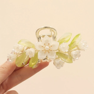 Detail of lily of the valley hair claw clip with pearls and green leaves accents