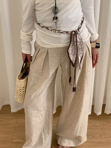Détail d'une ceinture écharpe en soie bohème avec perles en bois sur pantalon en lin