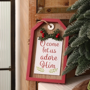 Vintage Christmas wooden door sign with red O Come Let Us Adore Him text and pine decor