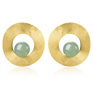 Macro detail of S925 silver stud earring with brushed gold texture and green stone
