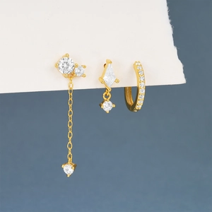 Macro detail of three-piece gold plated silver earrings set with sparkling zircon stones