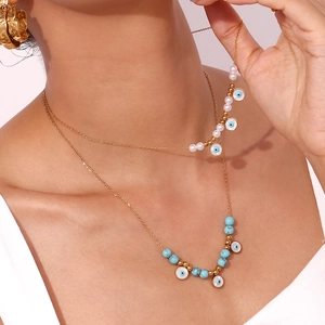Detail of 18K gold-plated double-layer necklace with turquoise beads and evil eye charm