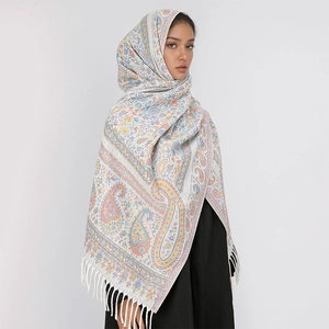 Detail of pink and blue paisley patterned winter shawl with elegant white fringes