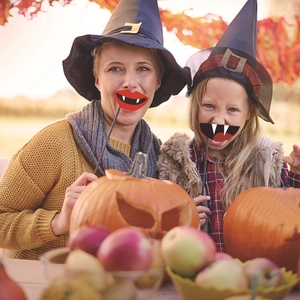 20-piece Halloween photo booth props with vampire lips mask held by happy family