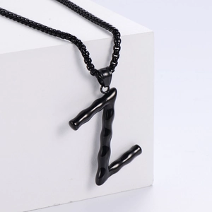 Vue macro du pendentif lettre Z noir 3D avec texture bambou sur chaîne en acier inox