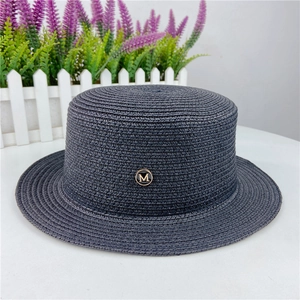 Close-up of dark blue boater hat with a circular golden metal M logo badge