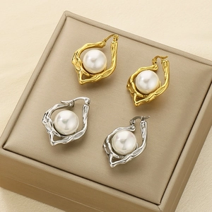 Detailed view of irregular hammered gold and silver hoops with inlaid white pearls