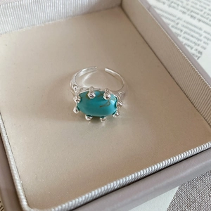 Macro view of oval turquoise stone and irregular artistic metal frame on ring