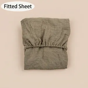 Detail of baby fitted sheet with elastic band and natural wrinkled cotton gauze texture