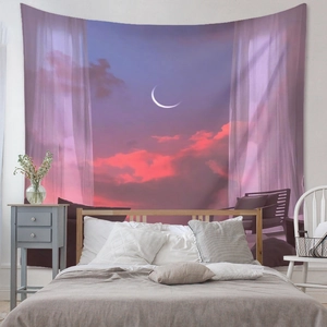 Bedroom setup showing a dreamy sunset tapestry with crescent moon and pink clouds
