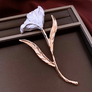 Détail de la broche tulipe aux pétales argentés texturés et tige en or rose élégante