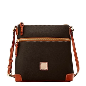 Detail of lychee textured leather crossbody bag with vintage golden metal logo plate