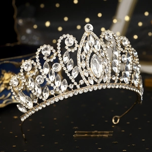 Gedetailleerd beeld van luxe gouden bruidstiara met strassteentjes op donkere achtergrond